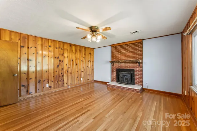 a view of an empty room with a fireplace and a window