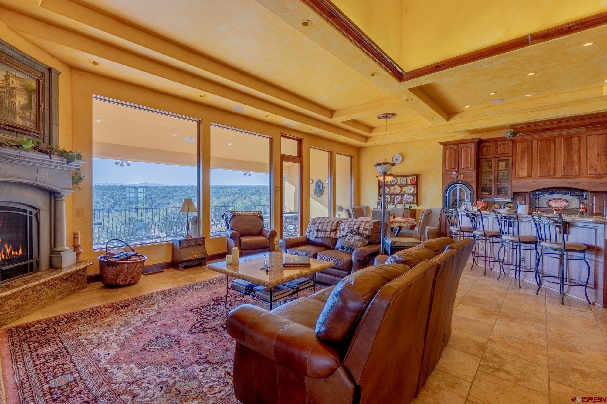 19754 Dave Wood Road Montrose, CO 81403 - Photo 12 of 35 a living room with furniture a fireplace and a floor to ceiling window