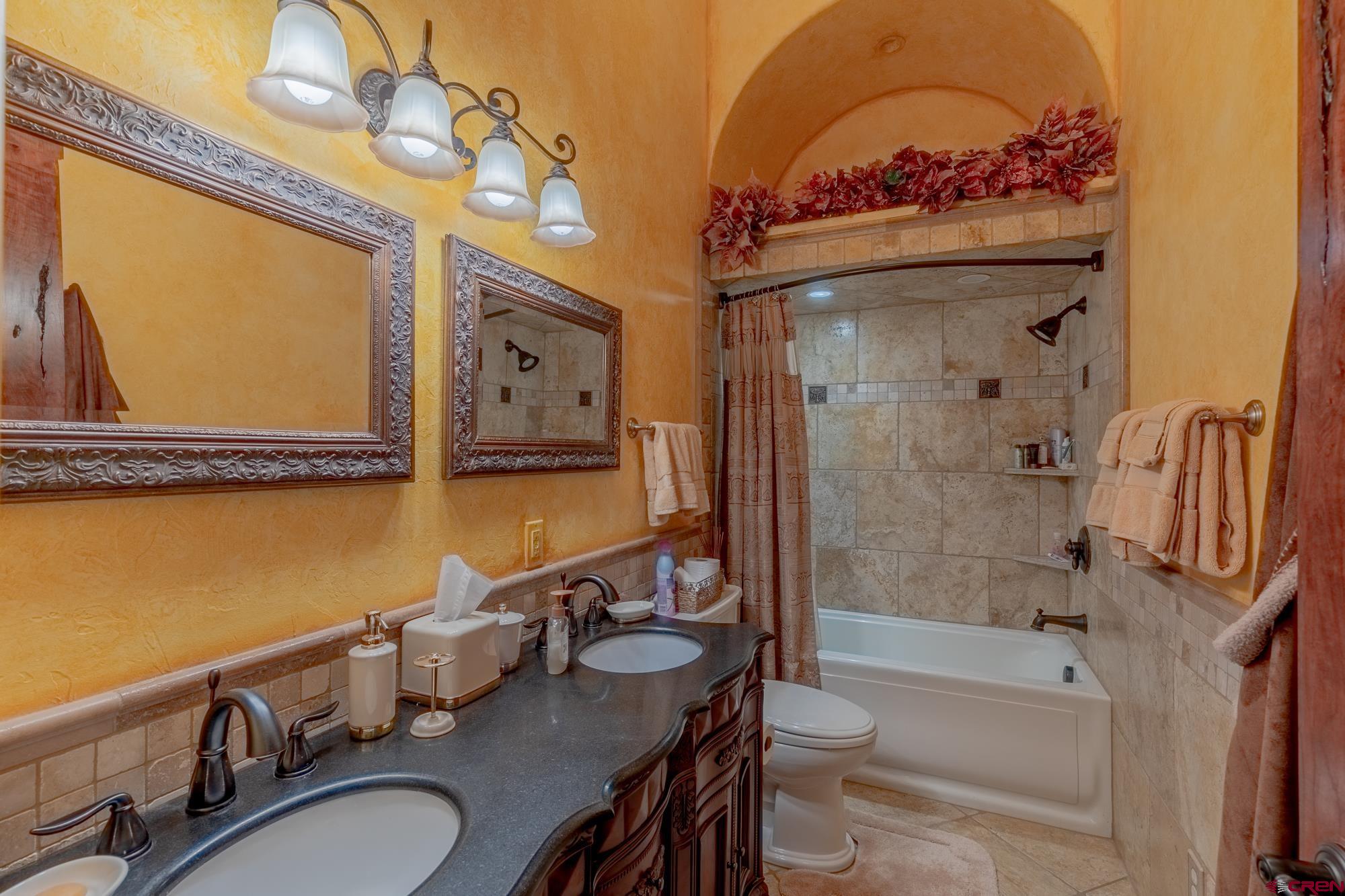 19754 Dave Wood Road Montrose, CO 81403 - Photo 20 of 35 a bathroom with a granite countertop sink a toilet a mirror and shower