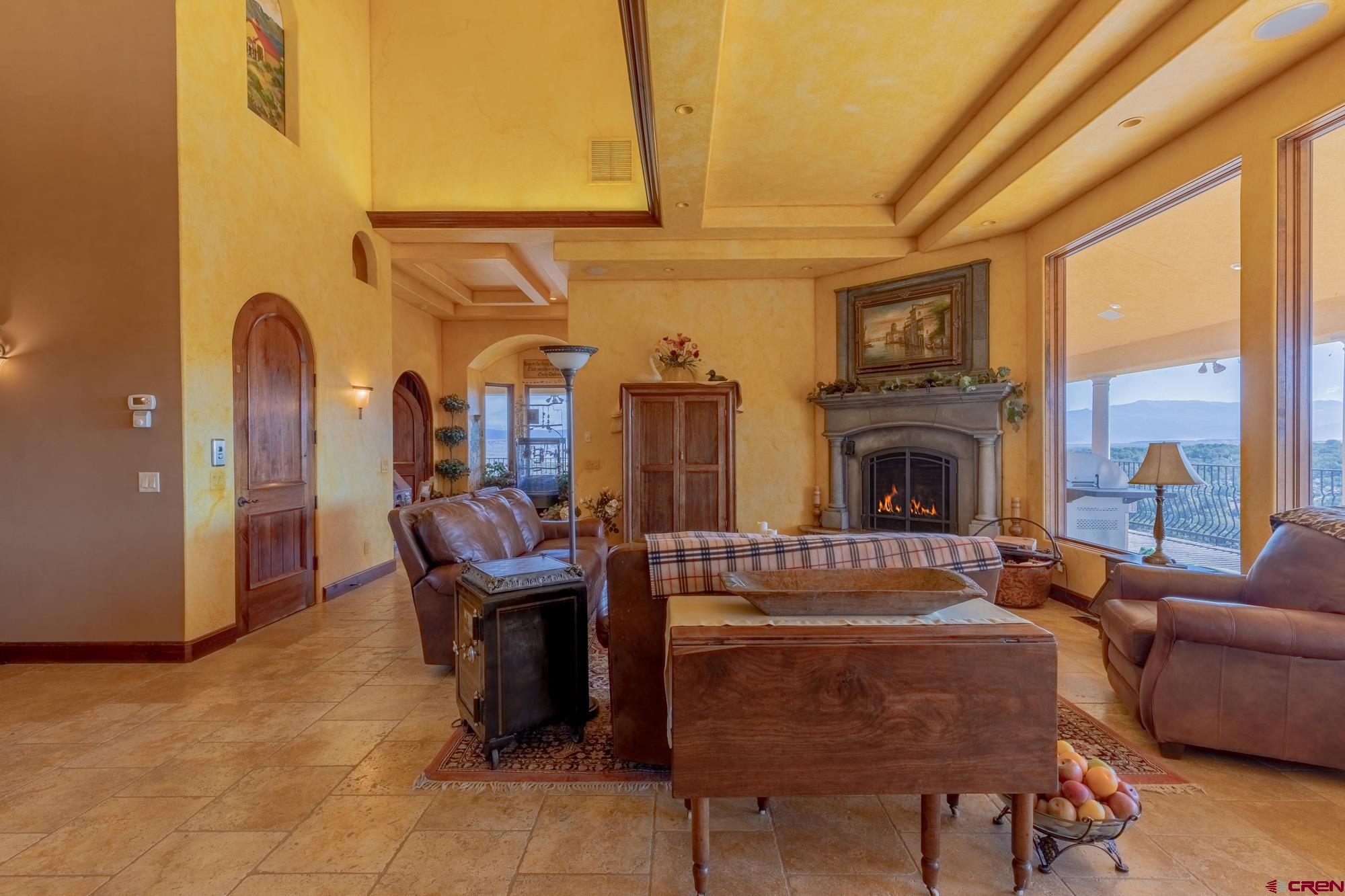 19754 Dave Wood Road Montrose, CO 81403 - Photo 9 of 35 a living room with furniture a large window and a fireplace
