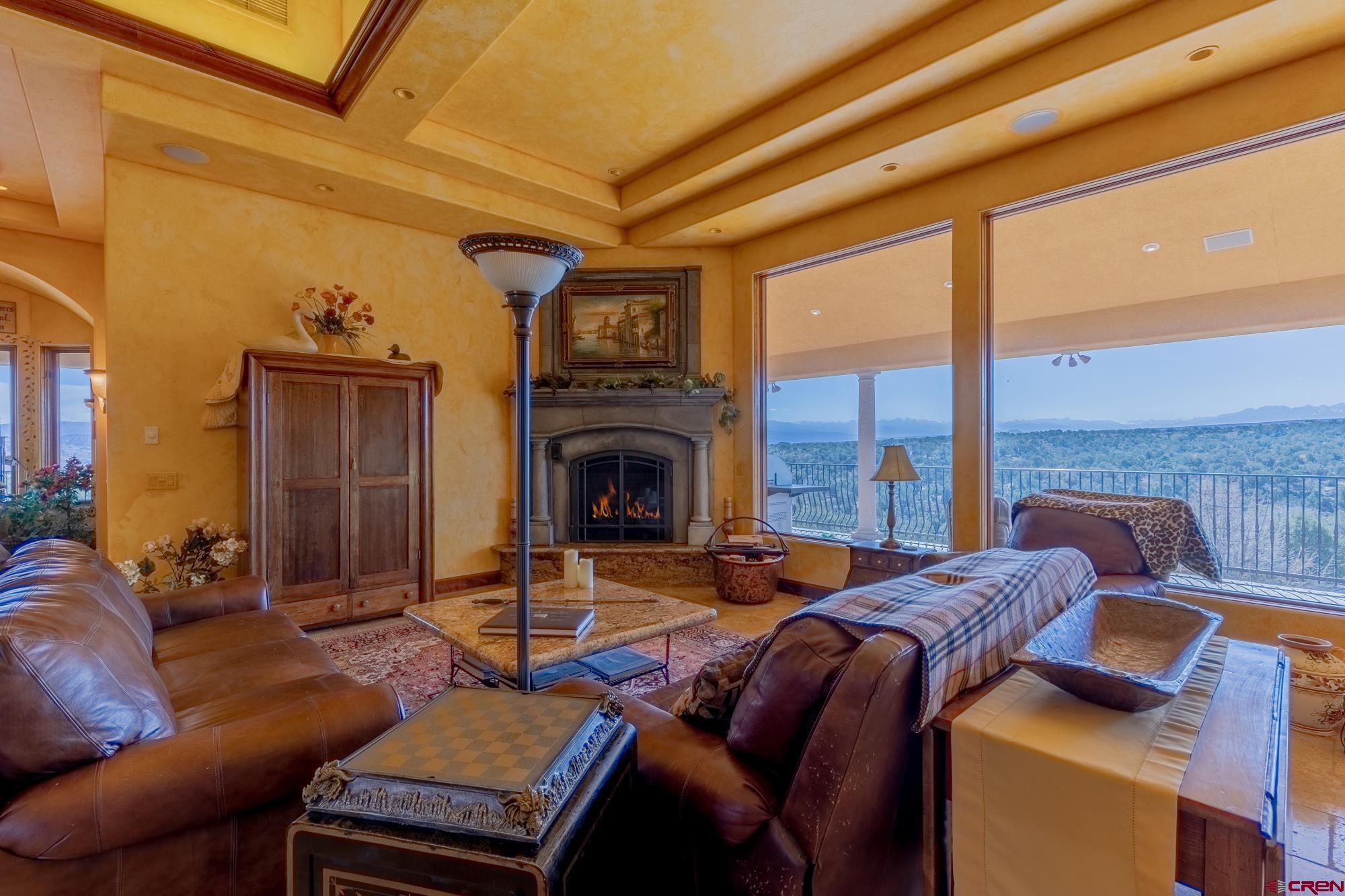 19754 Dave Wood Road Montrose, CO 81403 - Photo 10 of 35 a living room with furniture a fireplace and a floor to ceiling window