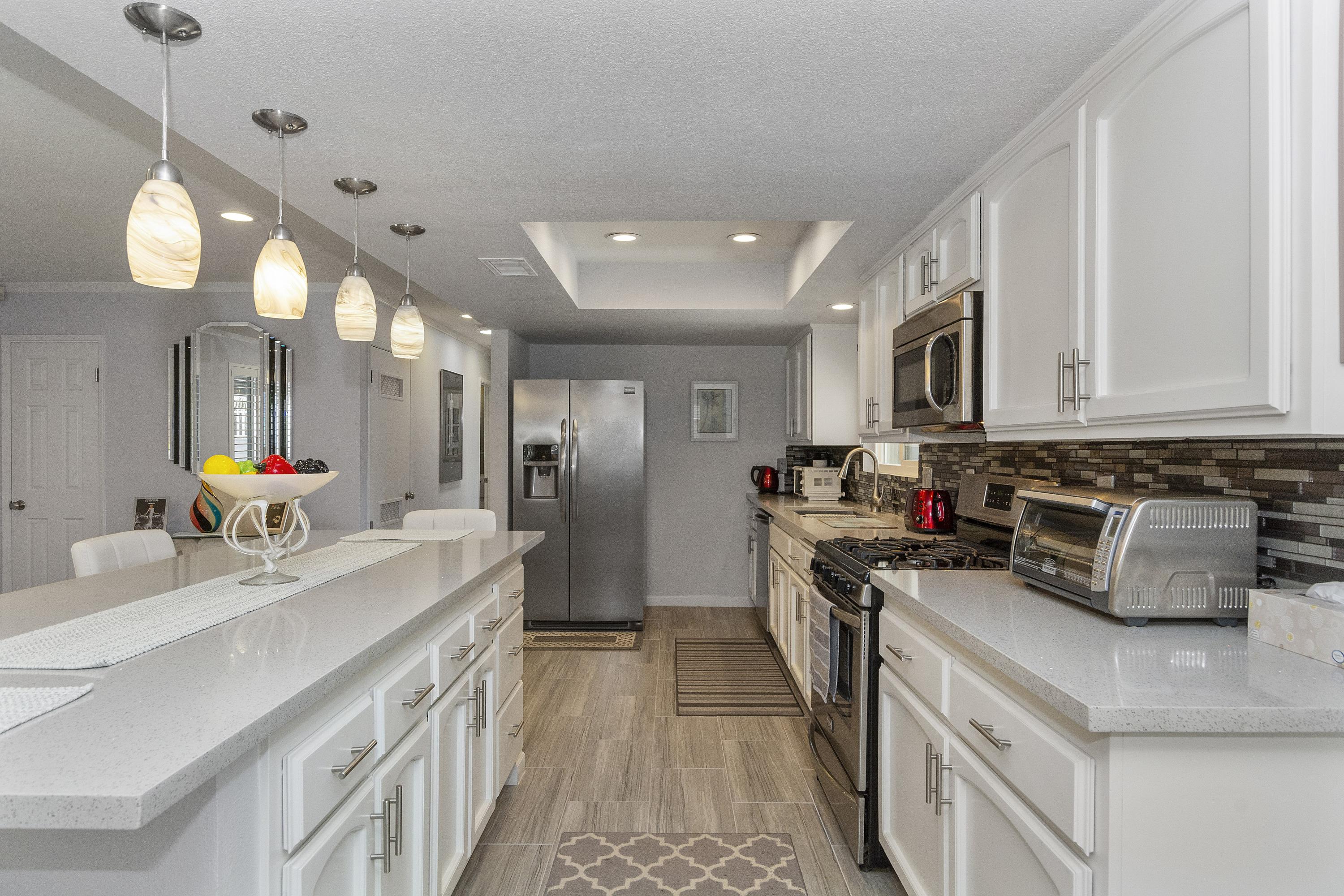 70061 Cobb Road Rancho Mirage, CA 92270 - Photo 11 of 33 a kitchen with kitchen island granite countertop a sink appliances and cabinets