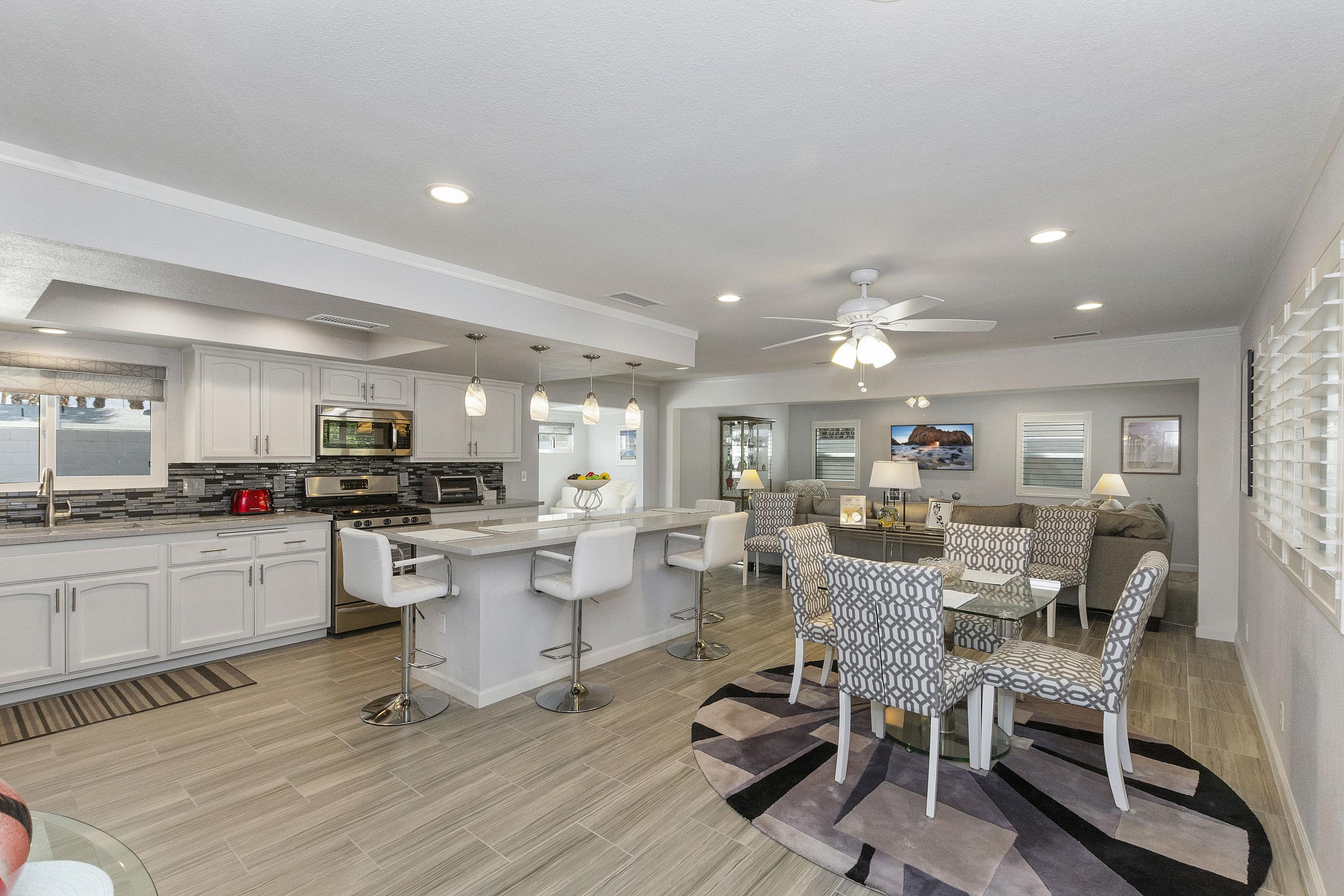 70061 Cobb Road Rancho Mirage, CA 92270 - Photo 7 of 33 a view of a dining room kitchen with kitchen island stainless steel appliances refrigerator stove dining table and chairs