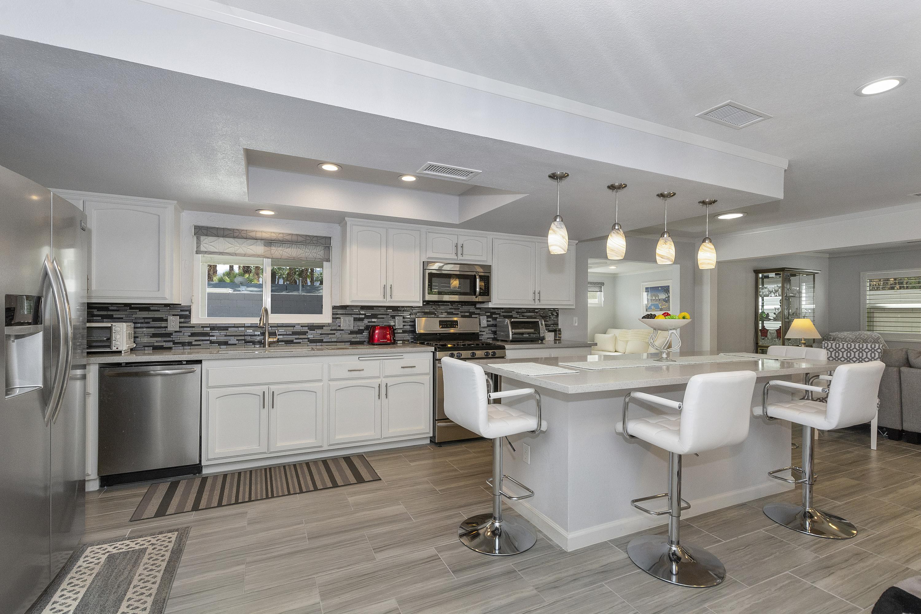 70061 Cobb Road Rancho Mirage, CA 92270 - Photo 8 of 33 a kitchen with white cabinets and stainless steel appliances
