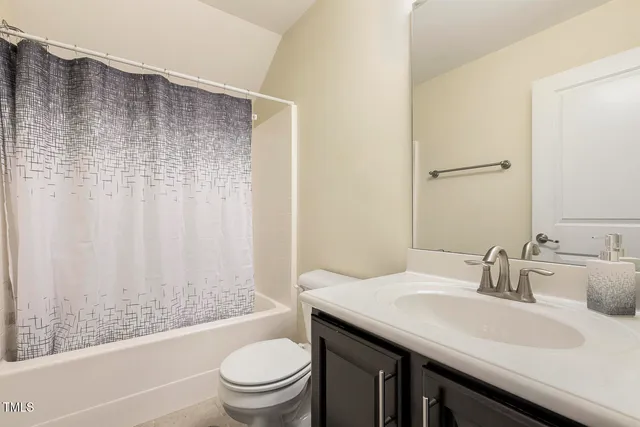 a bathroom with a granite countertop sink a toilet and shower