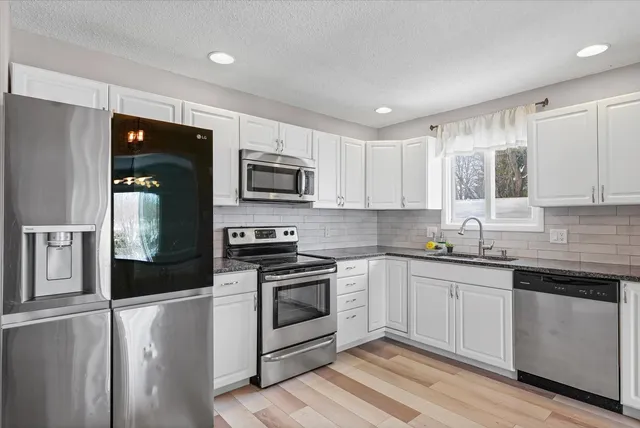 a kitchen with granite countertop a sink and cabinets