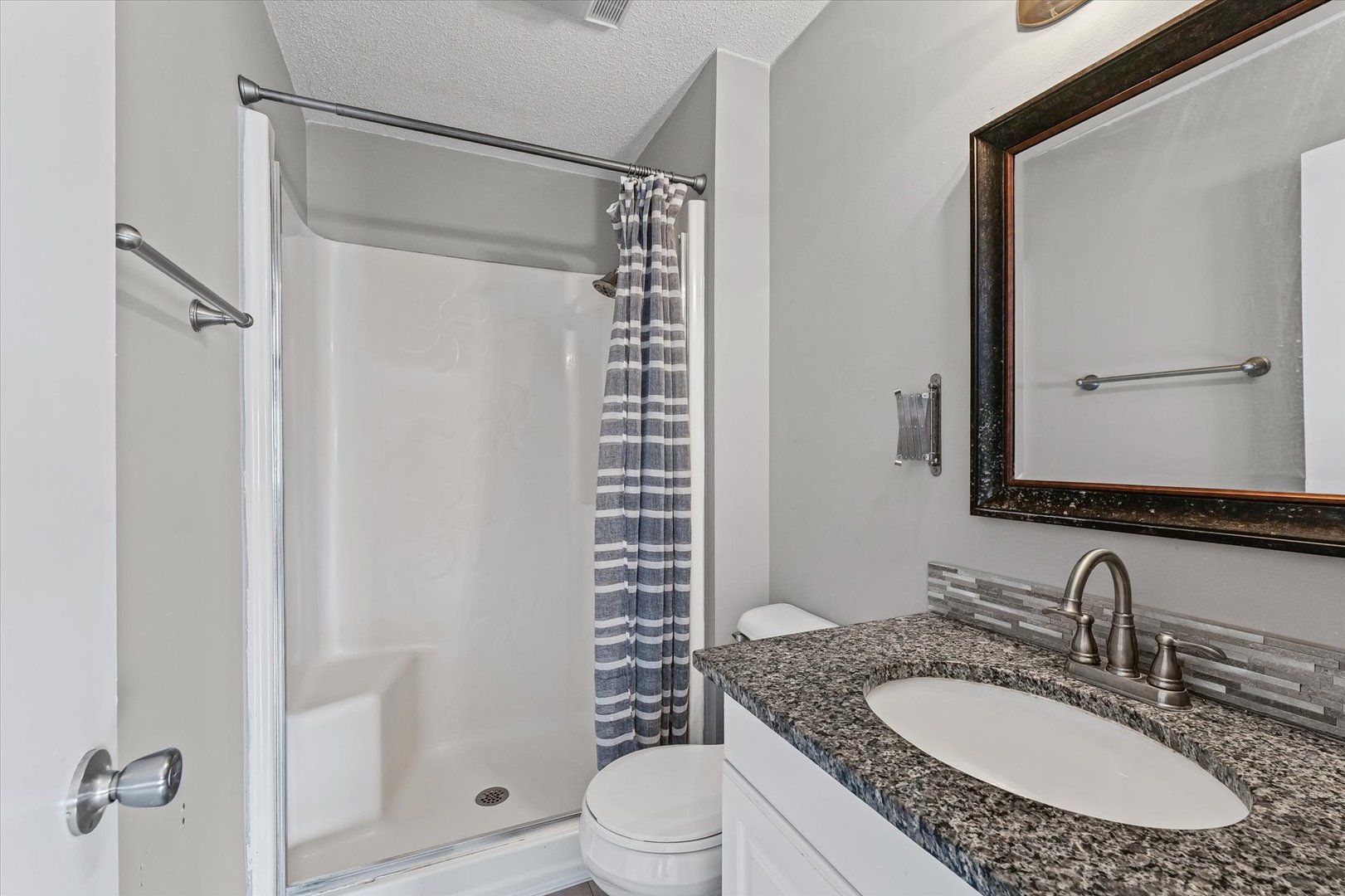 702 Devonshire Drive Champaign, IL 61820 - Photo 17 of 37 a bathroom with a granite countertop sink toilet a mirror a vanity and shower