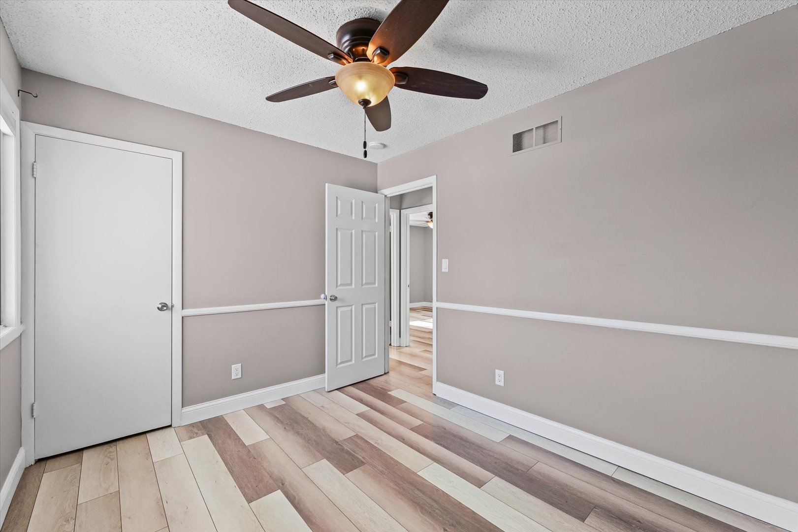 702 Devonshire Drive Champaign, IL 61820 - Photo 21 of 37 a view of a room with wooden floor and a ceiling fan