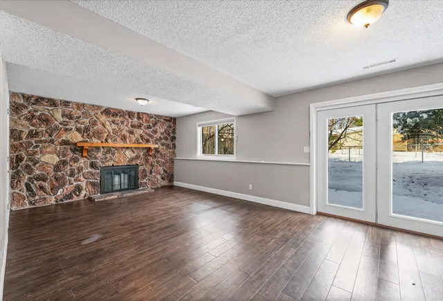 a view of empty room with wooden floor and fireplace