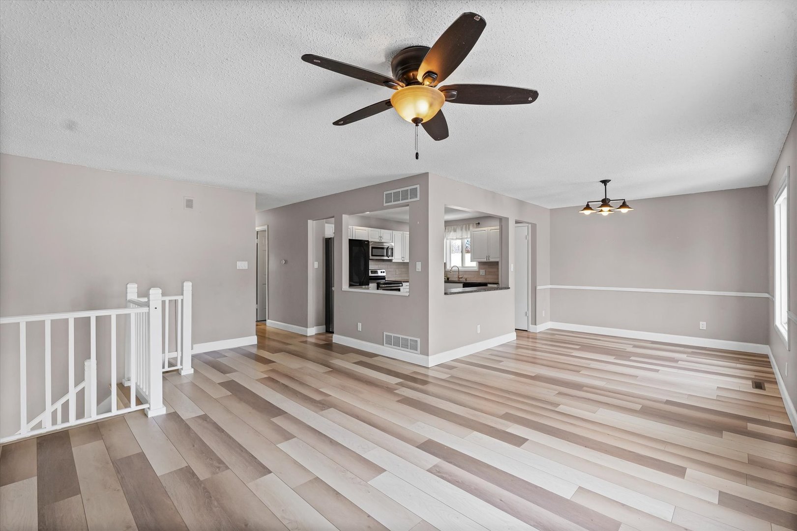 702 Devonshire Drive Champaign, IL 61820 - Photo 6 of 37 a view of an empty room with wooden floor and a ceiling fan