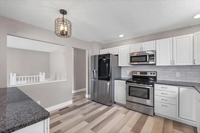a kitchen with stainless steel appliances granite countertop a sink and stove top oven