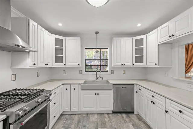 a kitchen with cabinets appliances a sink and a window