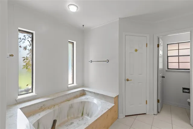 a bathroom with a tub shower and window