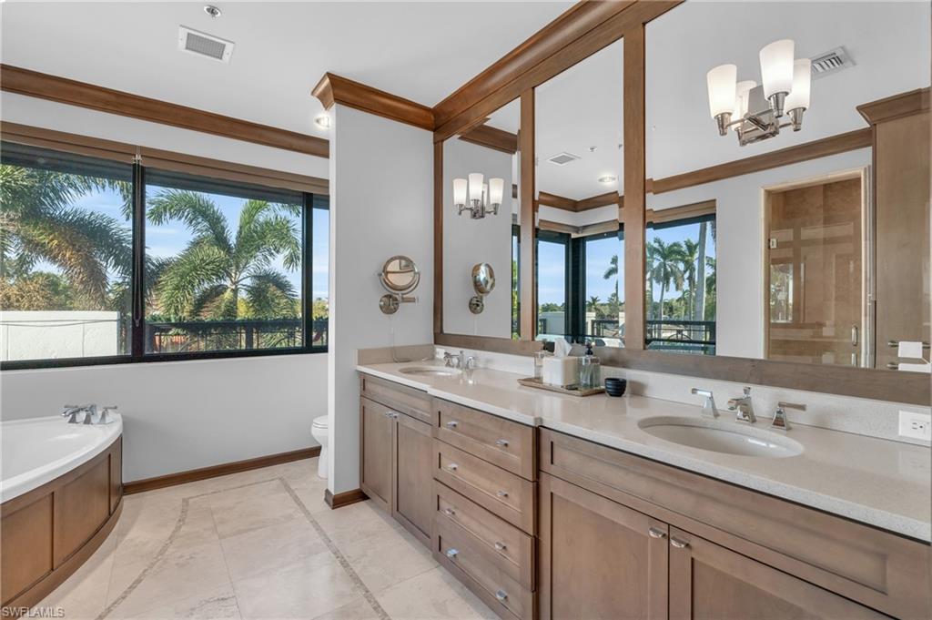 428 9th Street South Naples, FL 34102 - Photo 12 of 24 a bathroom with a double vanity sink and a large mirror