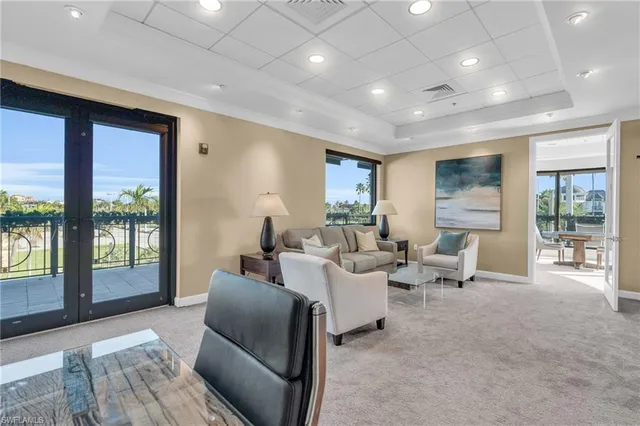 a living room with furniture large windows and a table