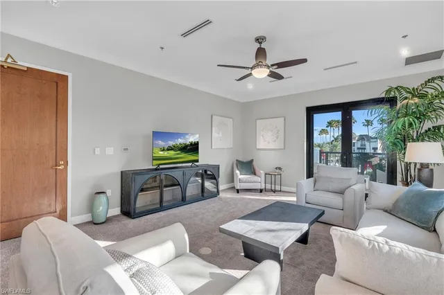 a living room with furniture a ceiling fan and a window