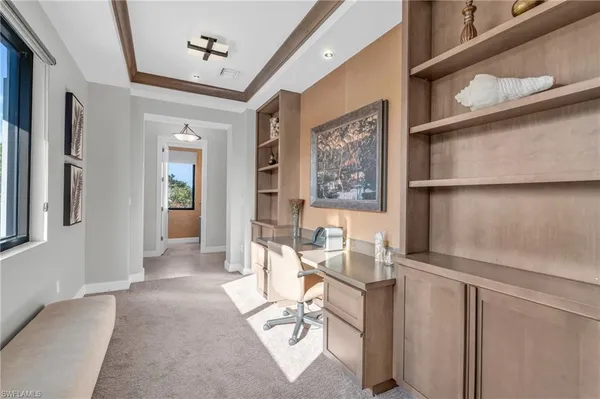 a view of a hallway with workspace and a window