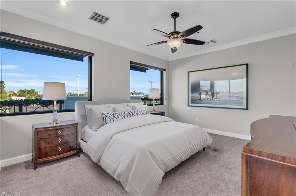 428 9th Street South Naples, FL 34102 - Photo 10 of 24 a bedroom with a large bed and a chandelier