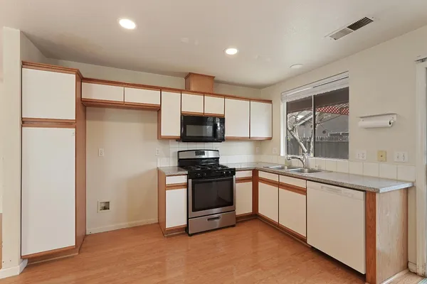 a kitchen with stainless steel appliances granite countertop a stove a sink and a refrigerator