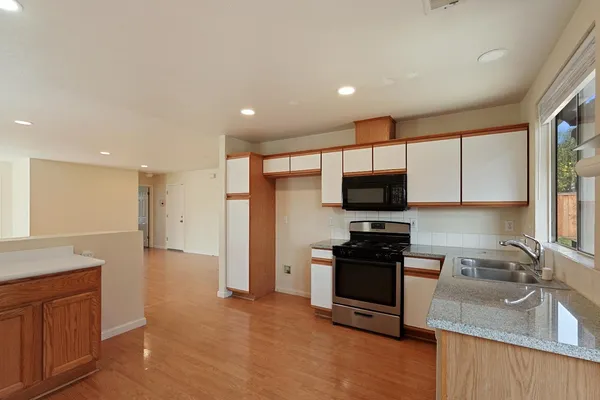 a kitchen with granite countertop a sink and a stove top oven with granite countertops
