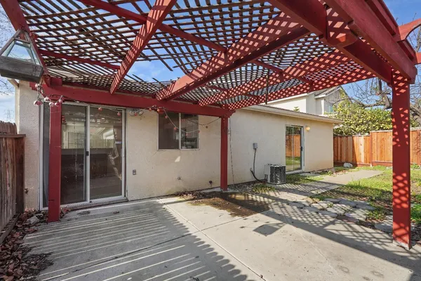 a view of a backyard with potted plants and large tree