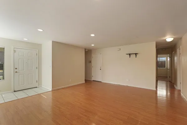 an empty room with wooden floor and windows