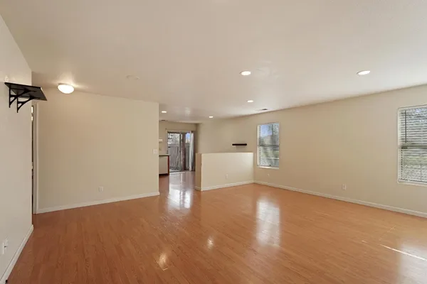 a view of a big room with wooden floor and windows