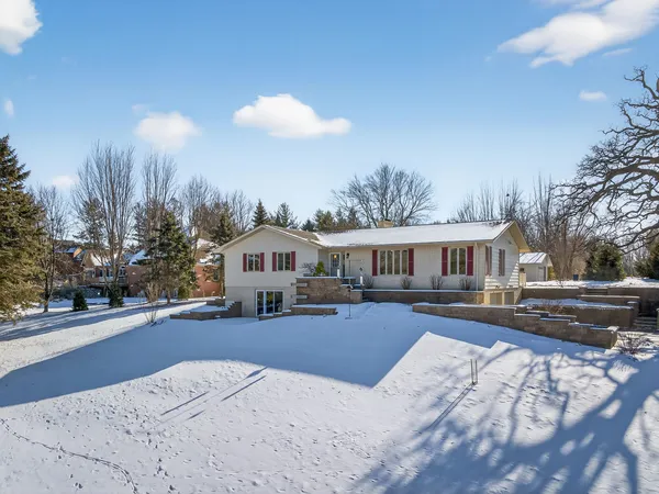 a view of a house with a yard covered in snow
