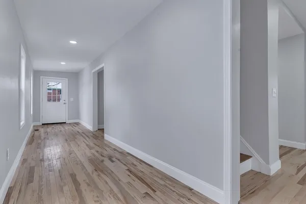 a view of hallway with wooden floor
