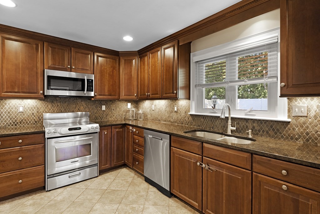 32 Concord Road Chelmsford, MA 01824 - Photo 10 of 27 a kitchen with granite countertop a stove microwave cabinets and sink
