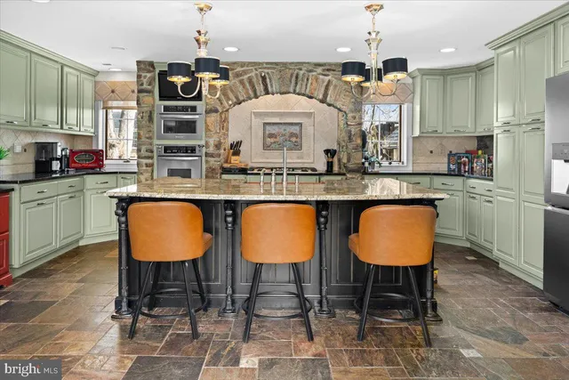 a kitchen with stainless steel appliances a dining table chairs sink and cabinets