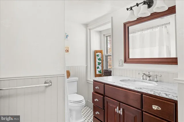 a bathroom with a granite countertop toilet sink and mirror