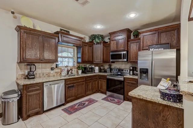 a kitchen with granite countertop stainless steel appliances and wooden cabinets