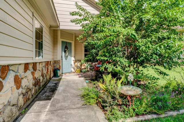 a view of a pathway with a fountain in front of house