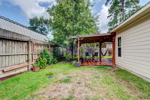 a view of a house with a yard and a large tree
