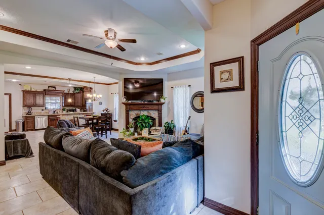 a living room with furniture a chandelier and a fireplace