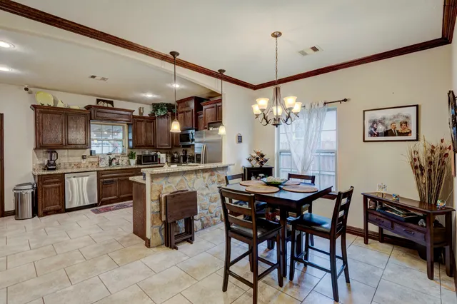 a kitchen with microwave a stove and chairs