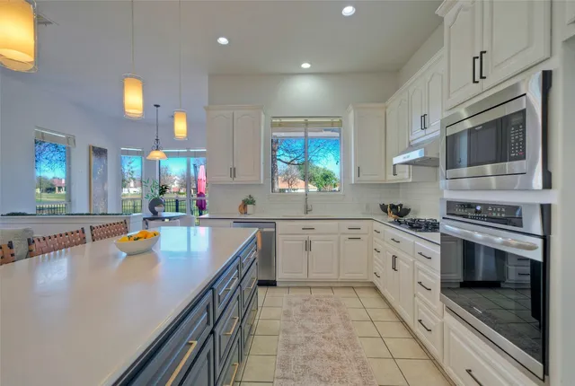 a kitchen with stainless steel appliances granite countertop a stove top oven a sink dishwasher and cabinets