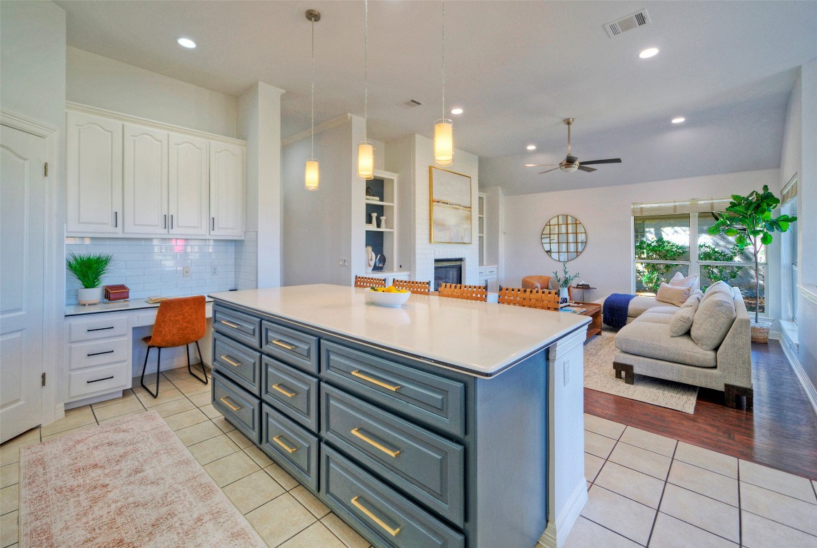 10833 Olympia Fields Loop Austin, TX 78747 - Photo 15 of 38 a kitchen with kitchen island granite countertop a sink and white cabinets