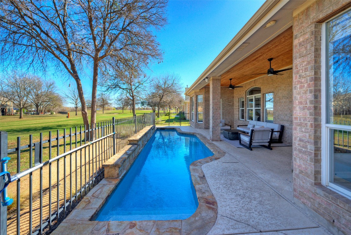 10833 Olympia Fields Loop Austin, TX 78747 - Photo 28 of 38 a swimming pool with lawn chairs and wooden fence