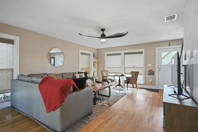 a living room with furniture a flat screen tv and a refrigerator
