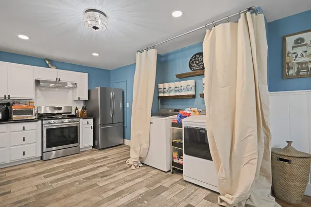 a kitchen with granite countertop a sink stainless steel appliances and white cabinets