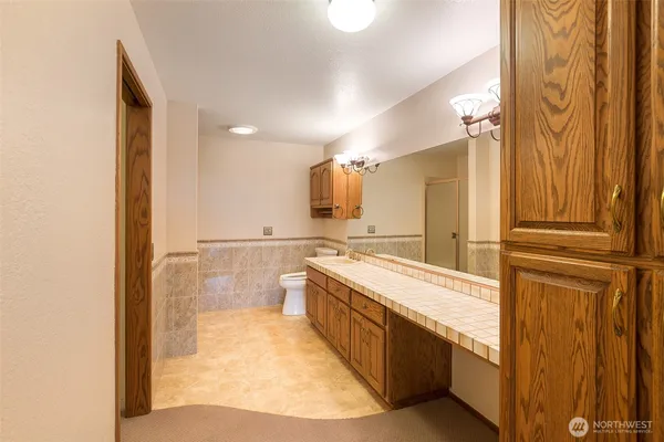 a large bathroom with a tub sink and mirror