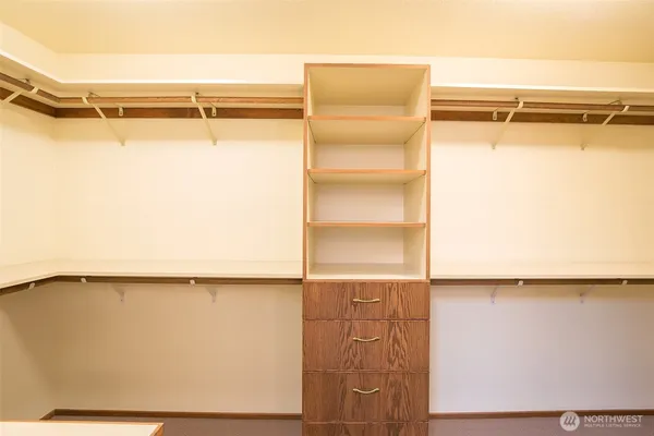 a view of walk in closet with clothes and shoes