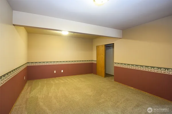 a view of a big room with wooden floor and windows