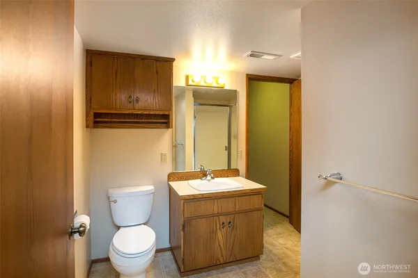 a bathroom with a granite countertop toilet and a sink