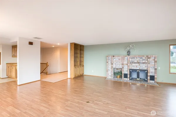 a view of empty room with wooden floor and fireplace