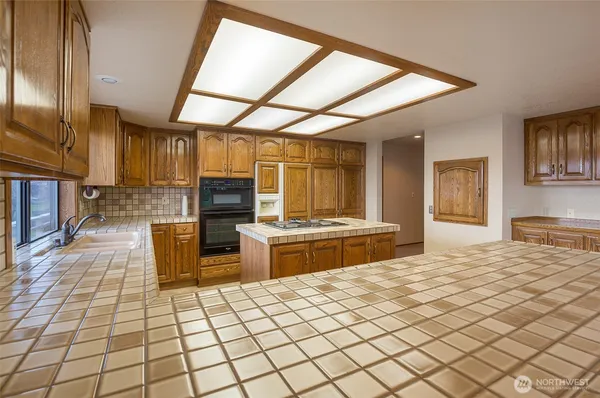 a kitchen with stainless steel appliances kitchen island granite countertop a refrigerator and a stove top oven