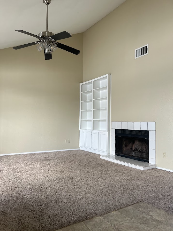 a view of an empty room with a fireplace and a window