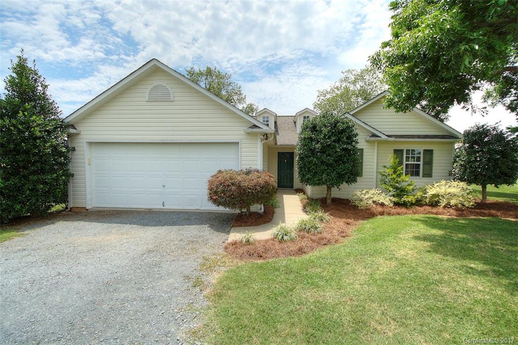 a view of a house with backyard and a tree